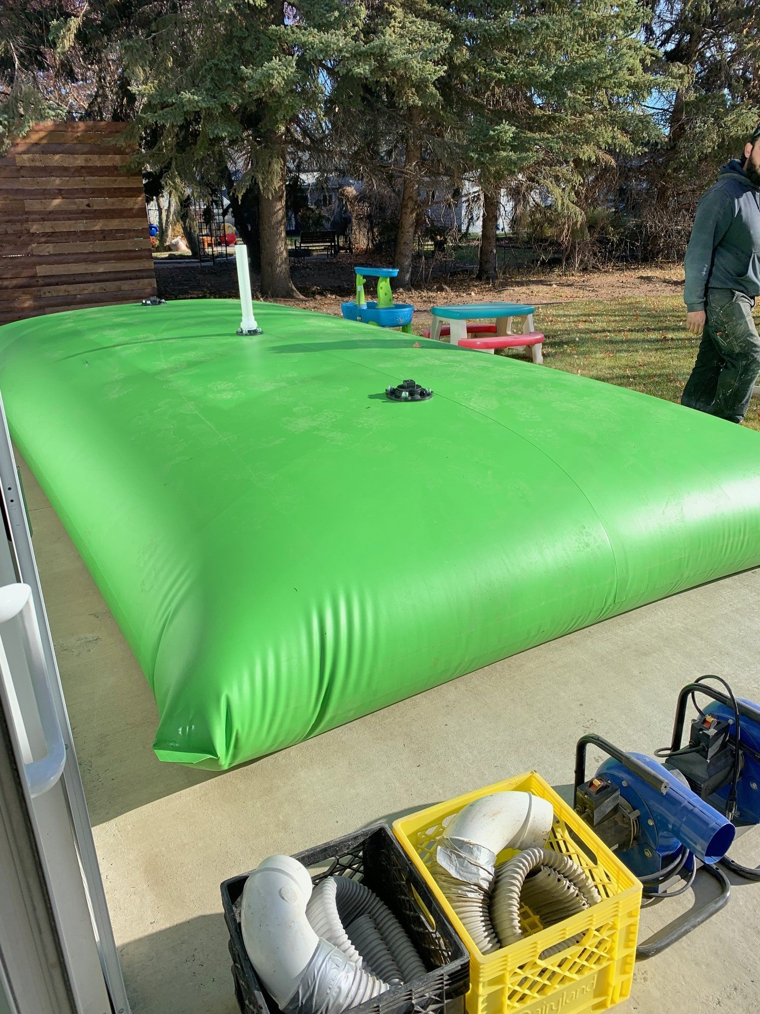 A pillow tank resting on a concrete pad, storing water for a homeowner.