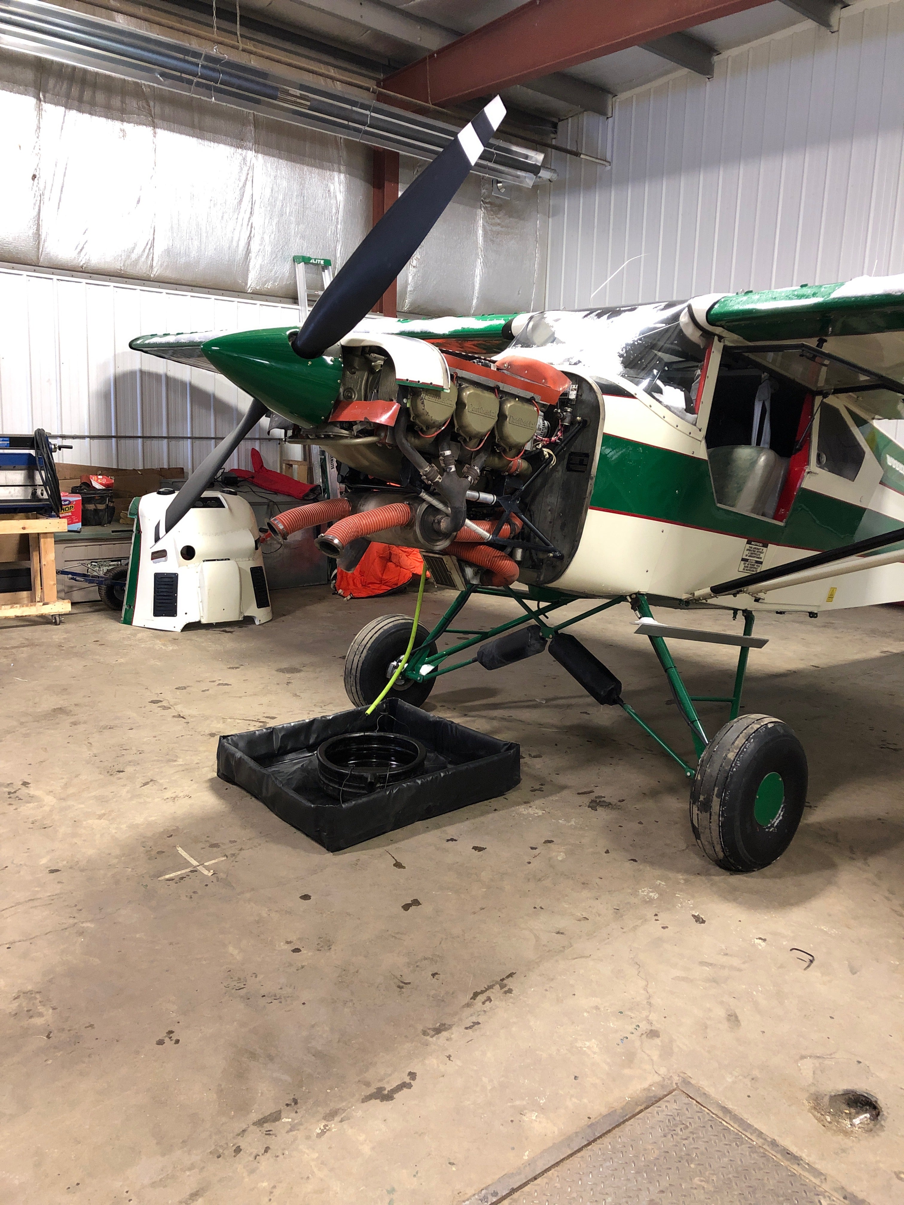 A 3x3 duck pond catching oil being drained from a float plane